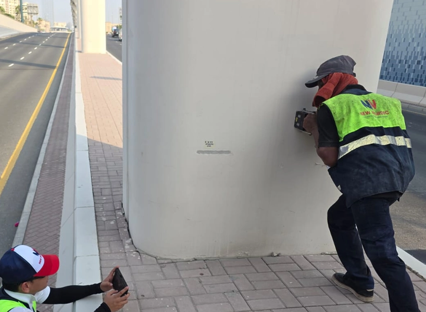 New Nordic engineers testing a bridge pier beside a highway carriageway and pedestrian walkway