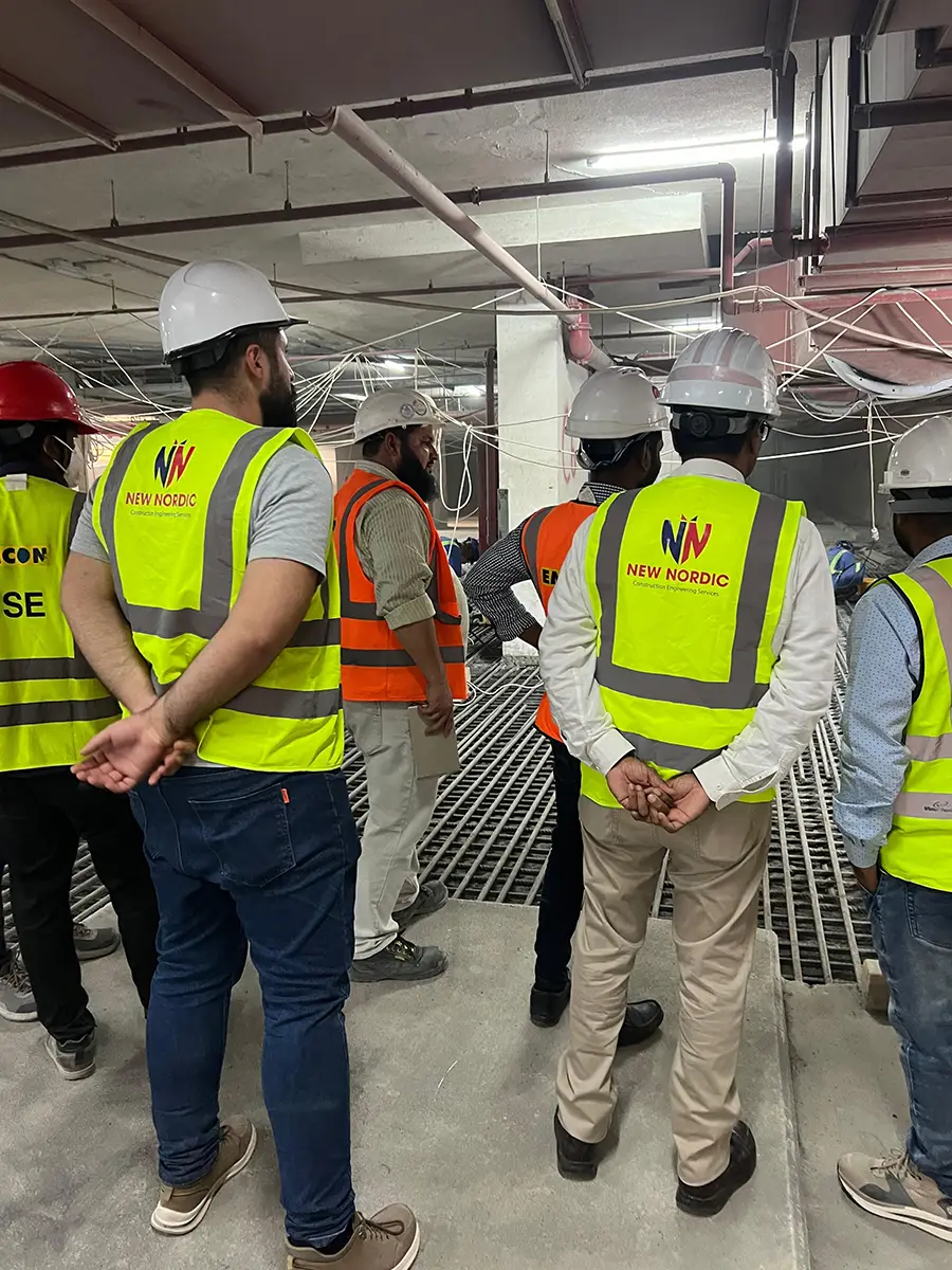 New Nordic engineers inspecting an exposed rebar ground slab inside an unfinished building