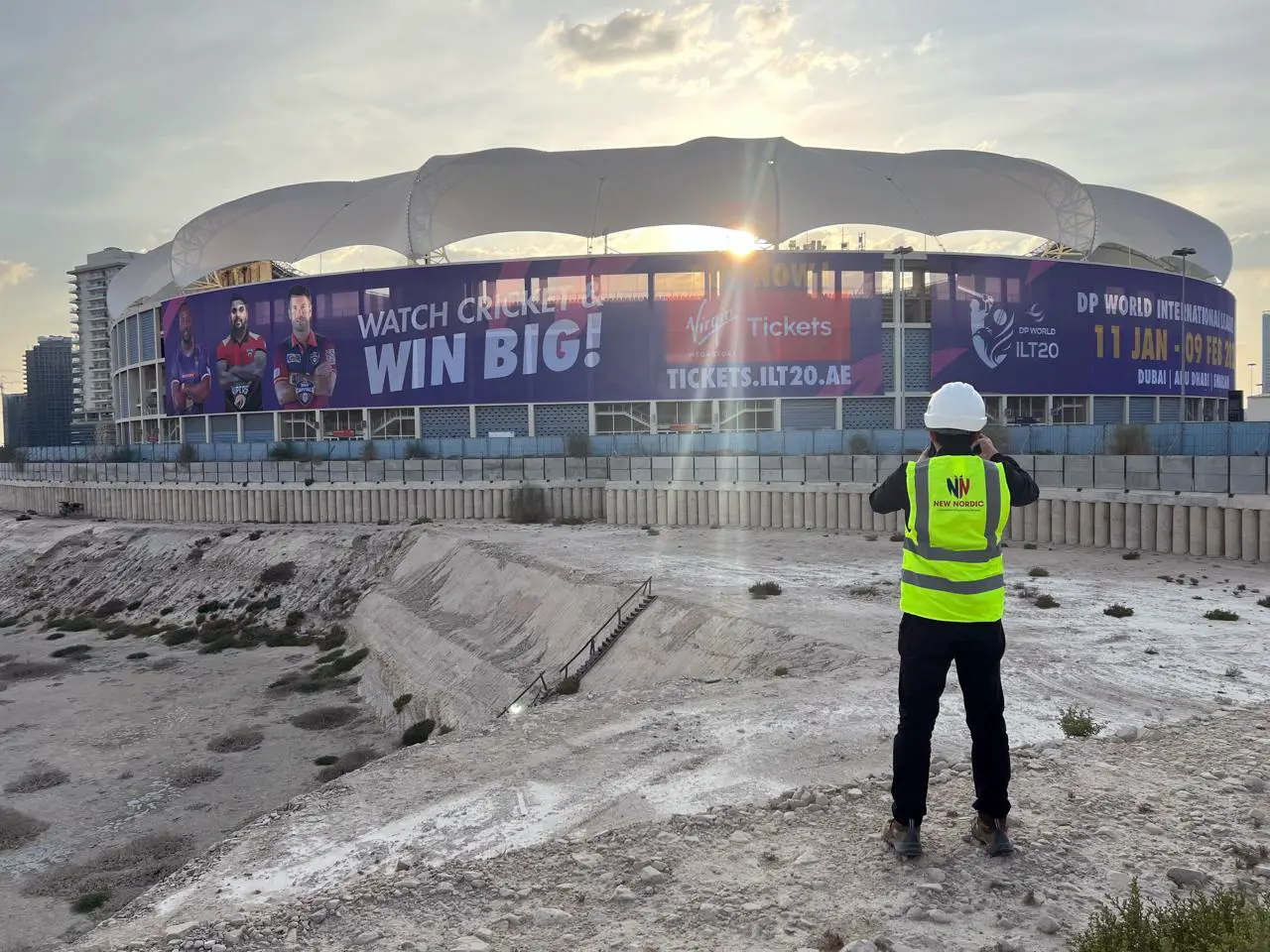 New Nordic engineer surveying a large stadium structure in Dubai