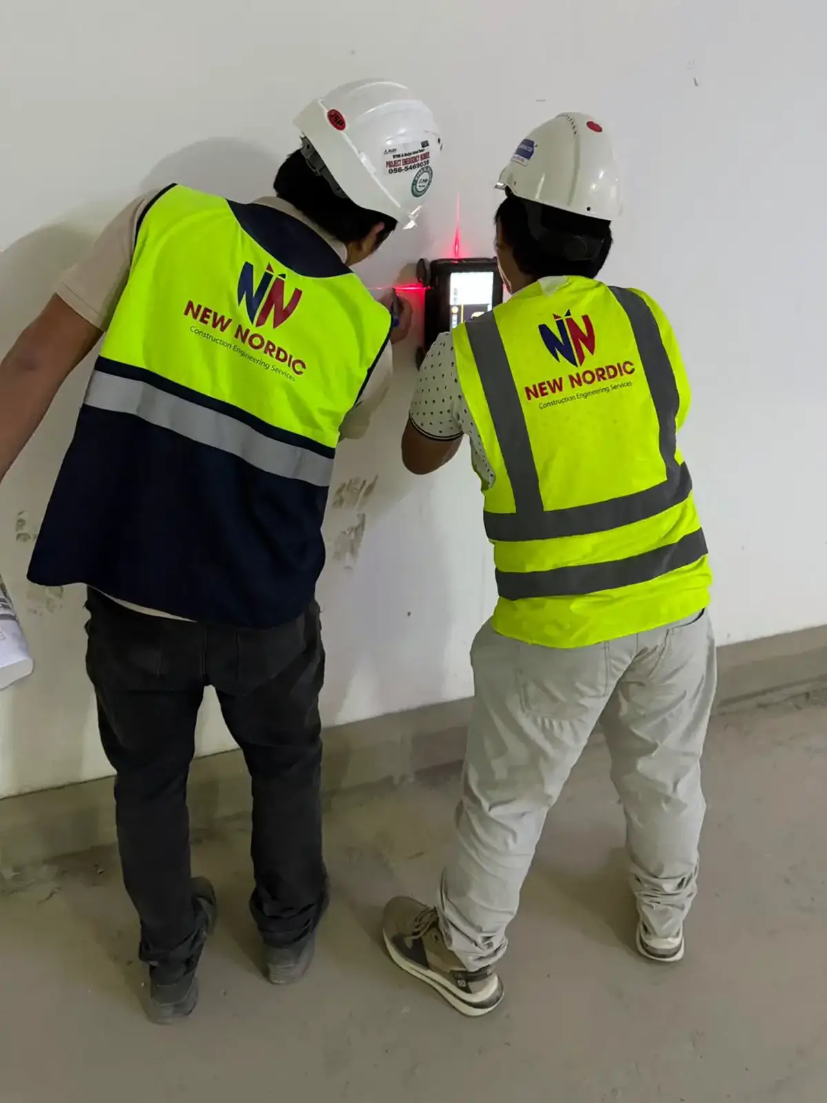 New Nordic engineers using handheld NDT scanning equipment on an interior wall
