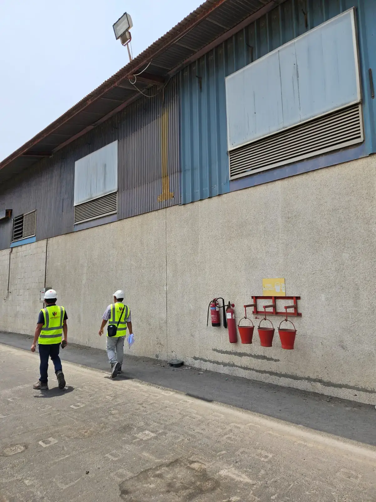 New Nordic engineers walking past a warehouse building at Ajman Port during a site inspection