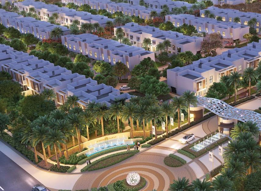 Aerial view of a landscaped villa community with palm-lined driveways and fountains