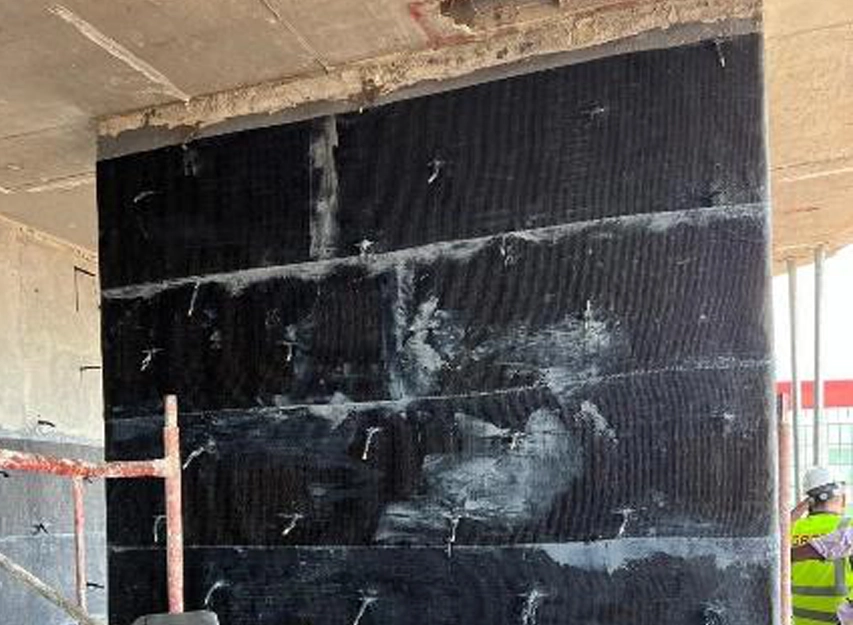 Concrete column wrapped in CFRP sheeting with a New Nordic engineer nearby